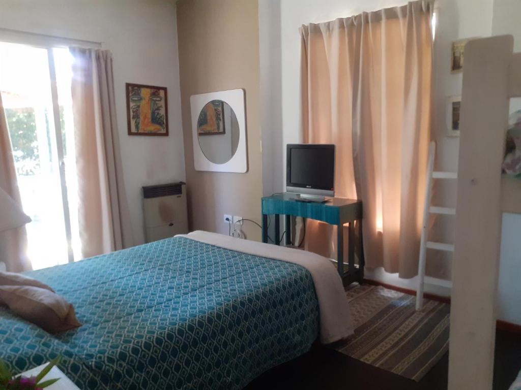 1 dormitorio con 1 cama y mesa con TV en Mendoza Leisure Time en Chacras de Coria
