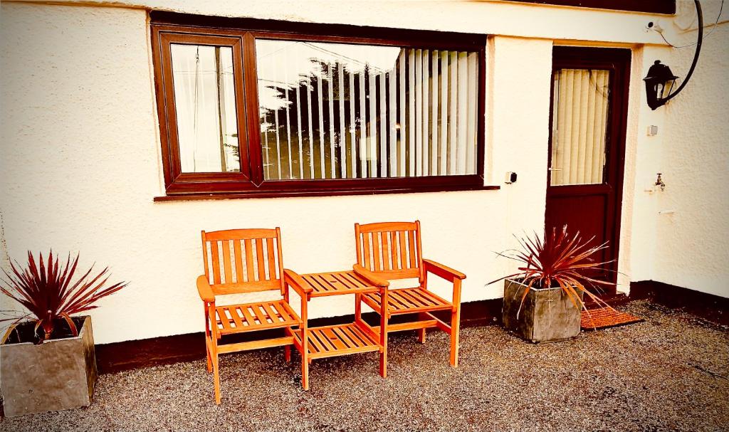 two chairs and a table in front of a house at Stunning Cottage in Holyhead in Holyhead