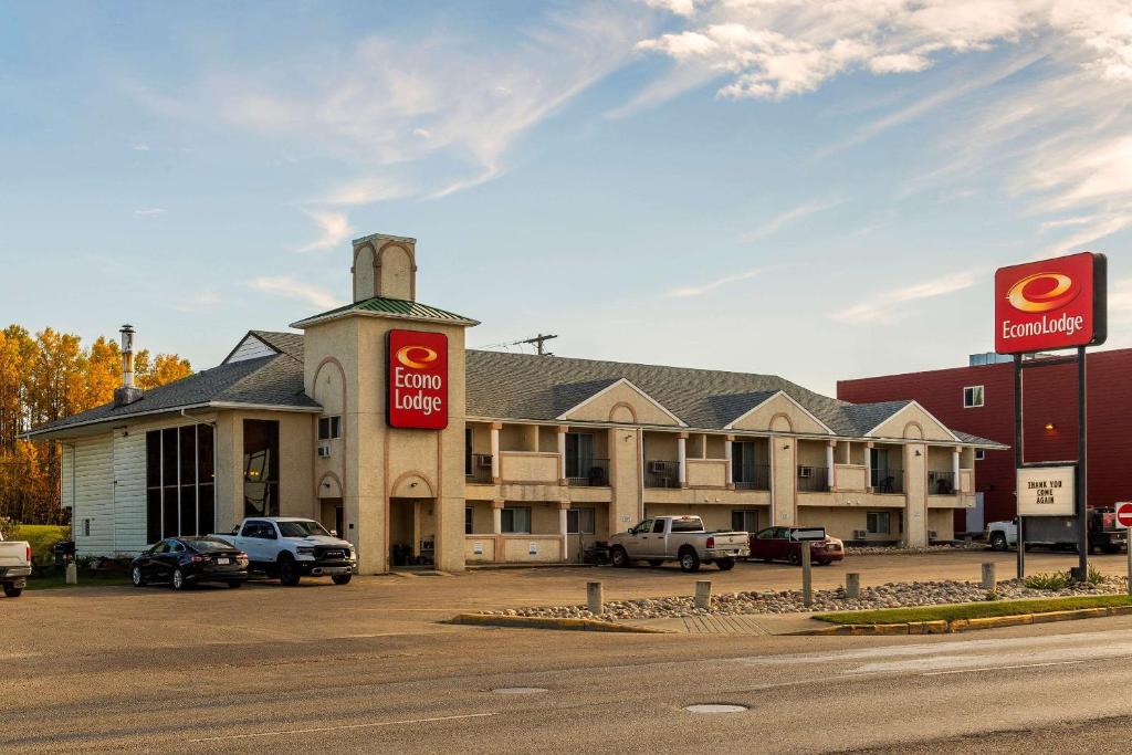 a hotel with cars parked in a parking lot at Econolodge Edson in Edson