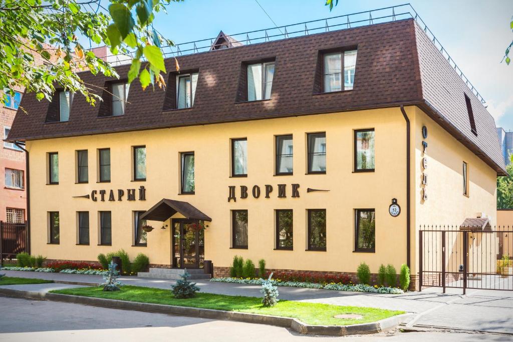 a large yellow building with a brown roof at Stariy Dvorik on Mopra in Kirov