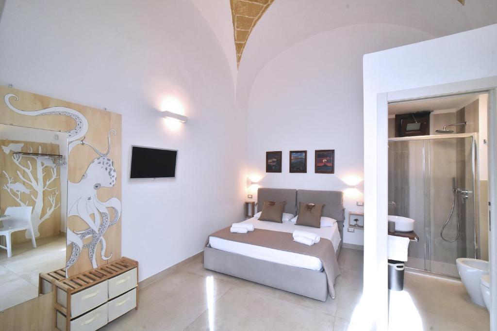a white bedroom with a bed and a bathroom at L'Antica Rimessa Da Gigi in Gallipoli