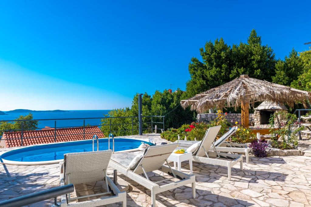 a group of chairs and a swimming pool at Charming Villa Svagusa with Sea View in Mlini