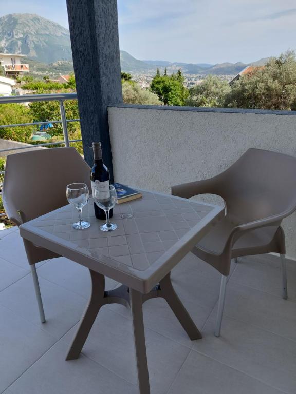 a table and two chairs with a bottle and two glasses at Apartments Tramonto in Bar