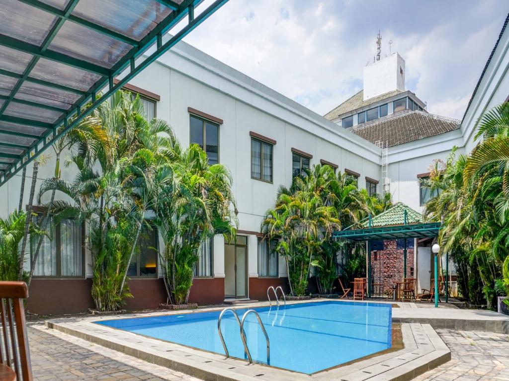 an exterior view of a building with a swimming pool at Townhouse OAK Hotel Grand Cikarang in Cikarang