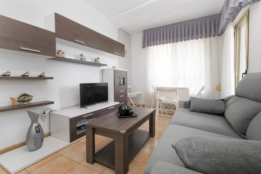 een woonkamer met een bank en een tv bij Santa Pola appartement Cosy in Santa Pola