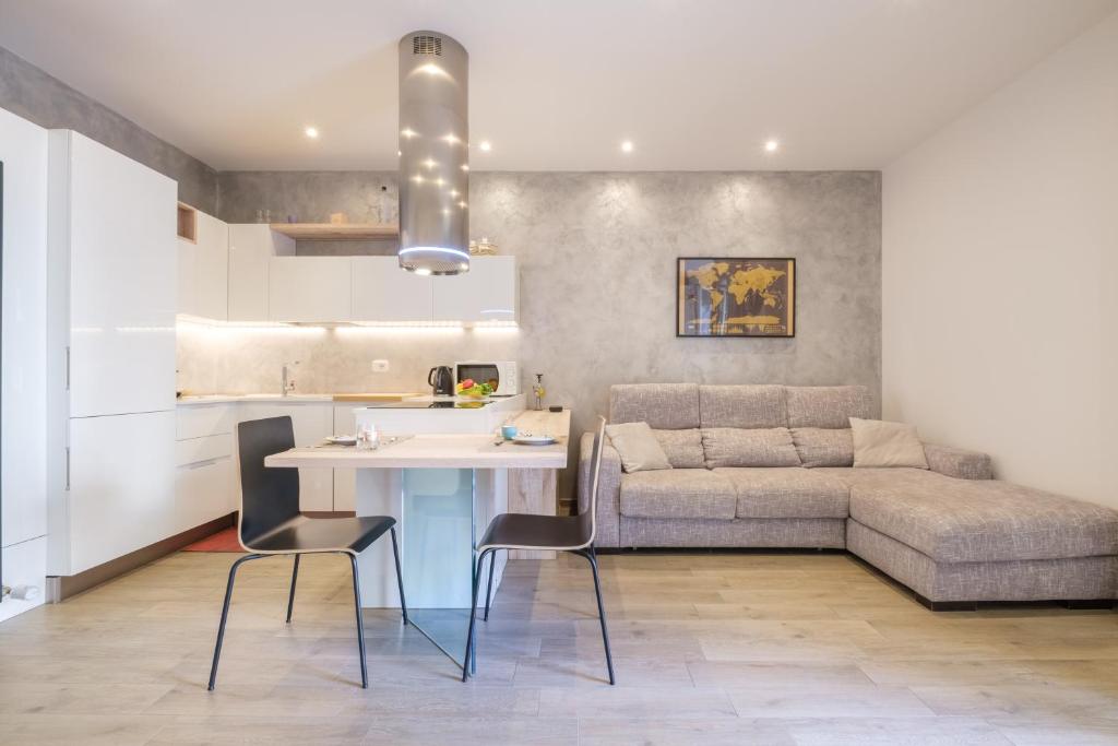 una cucina e un soggiorno con tavolo e divano di Residence Cairoli 9 by Studio Vita a Bologna