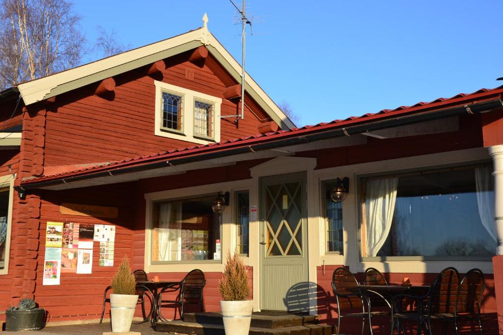 een rood huis met zwarte stoelen en een veranda bij Bruntegården in Rättvik