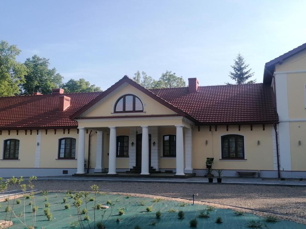 薩諾克的住宿－DOM WESELNY 'DWÓR W JUROWCACH'，一座大型白色房屋,设有红色屋顶