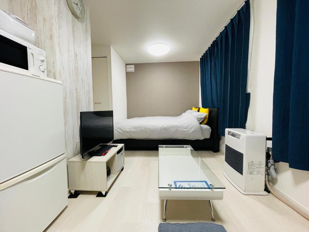 a small room with a bed and a table in it at （B10）NEW OPEN アクセス良好！リフォーム完了☆サービスアパ―トメントSAPPORO南8条B10 in Ōdōri