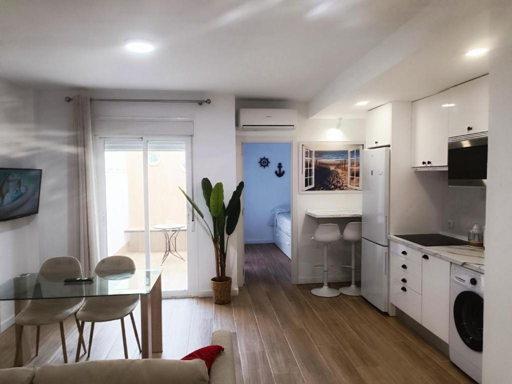 eine Küche und ein Wohnzimmer mit einem Tisch und Stühlen in der Unterkunft NUE - Nuevo, 2 dormitorios, Wifi, Smart TV, Playa in Fuengirola