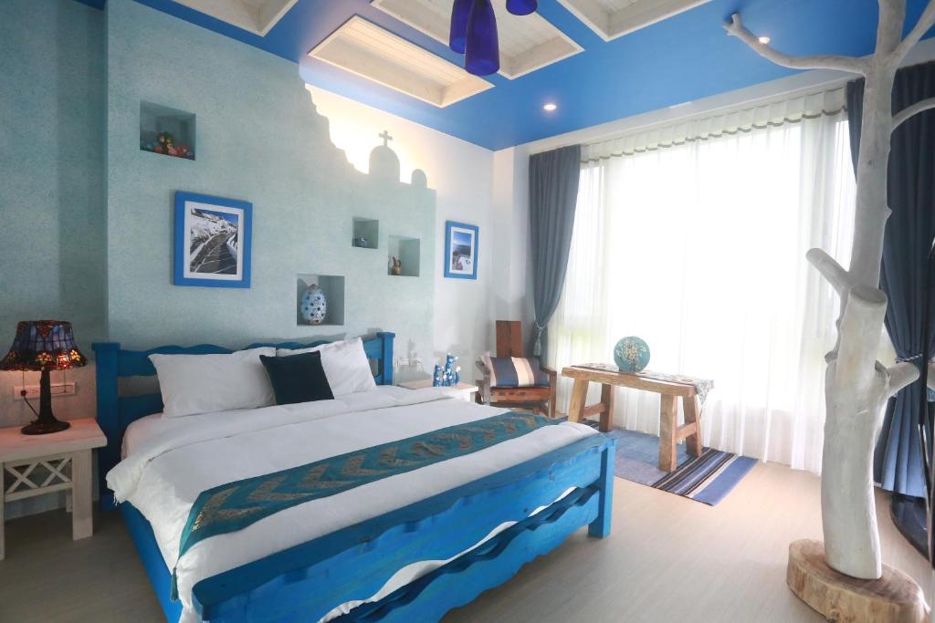a blue and white bedroom with a bed and a window at Jane Castle in Wujie