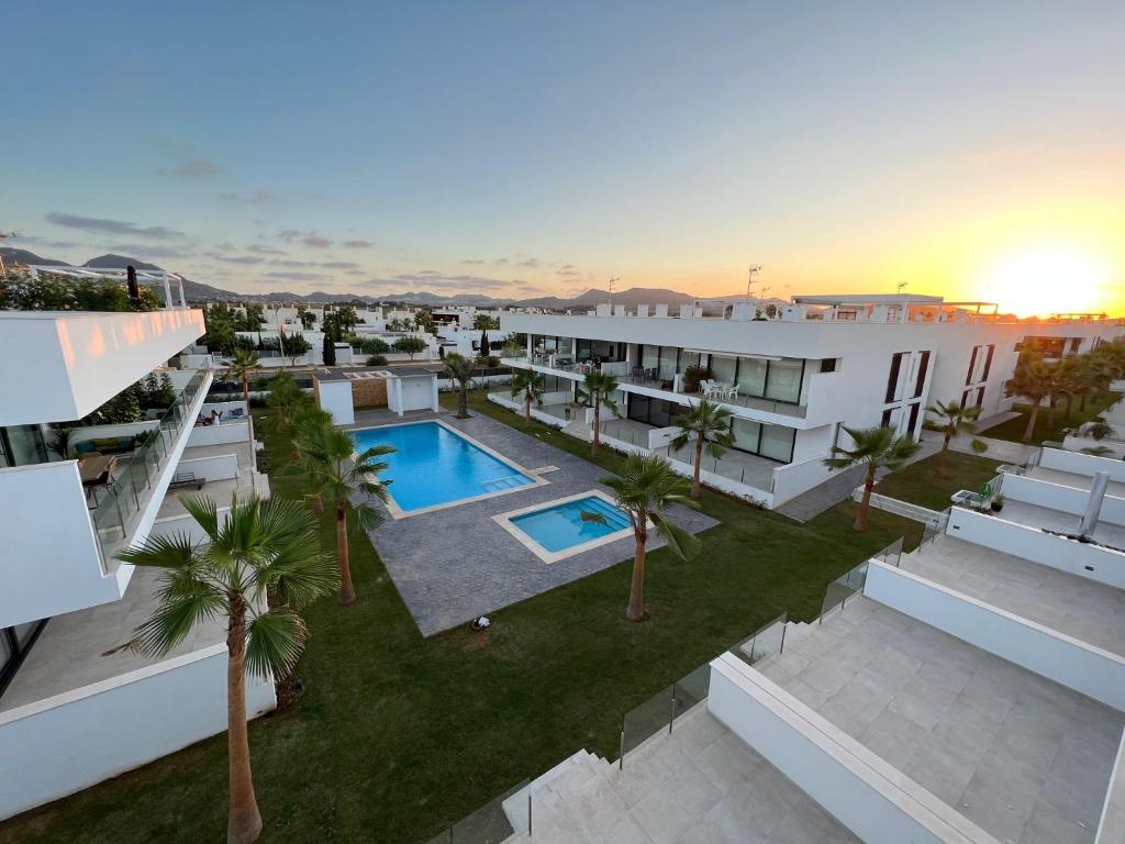una vista aérea de un edificio con piscina y palmeras en Outstanding 2 bed apartment with rooftop sea views, en Mar de Cristal