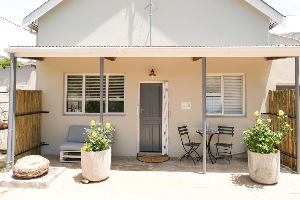 a house with a porch with chairs and a table at The Lemon Tree in Ceres