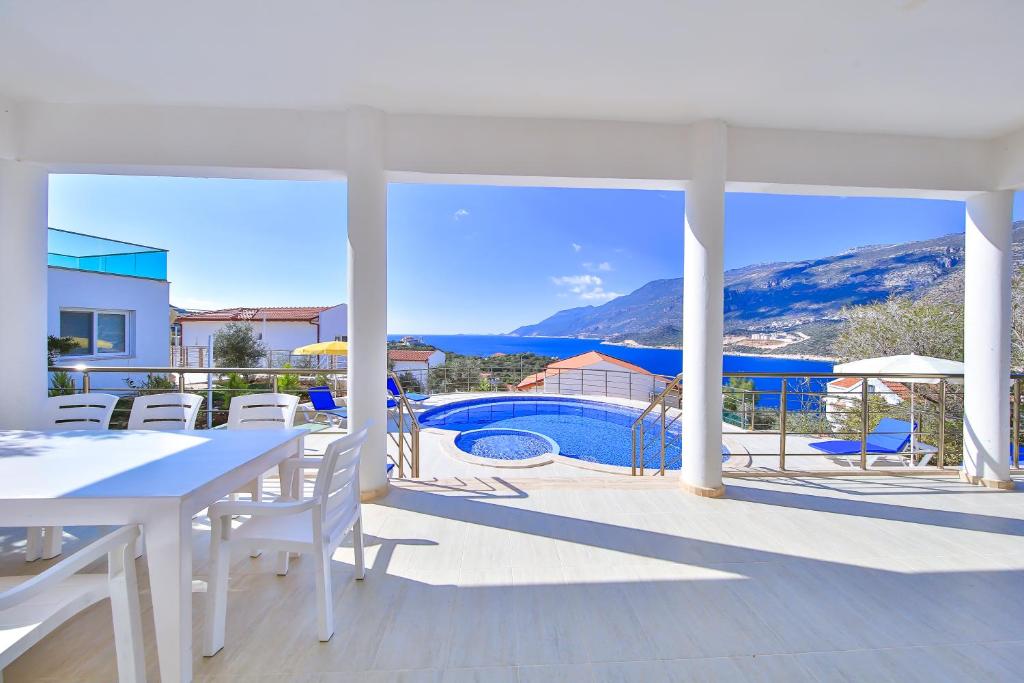 um pátio com uma mesa e cadeiras e uma piscina em Blue Sea View Villas - Kas Peninsula em Kas