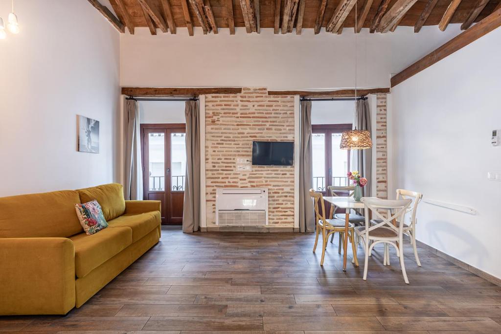 un soggiorno con divano e tavolo di Apartamentos Boutique Granada 3000 a Granada
