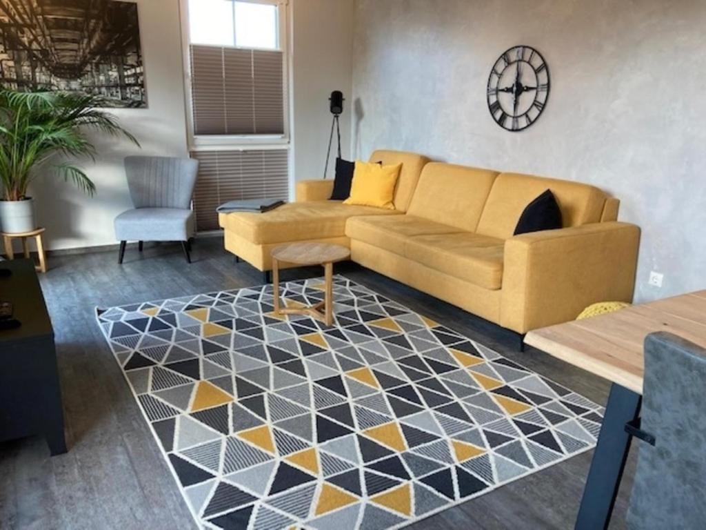 sala de estar con sofá amarillo y alfombra en Kabine 3, en Grömitz