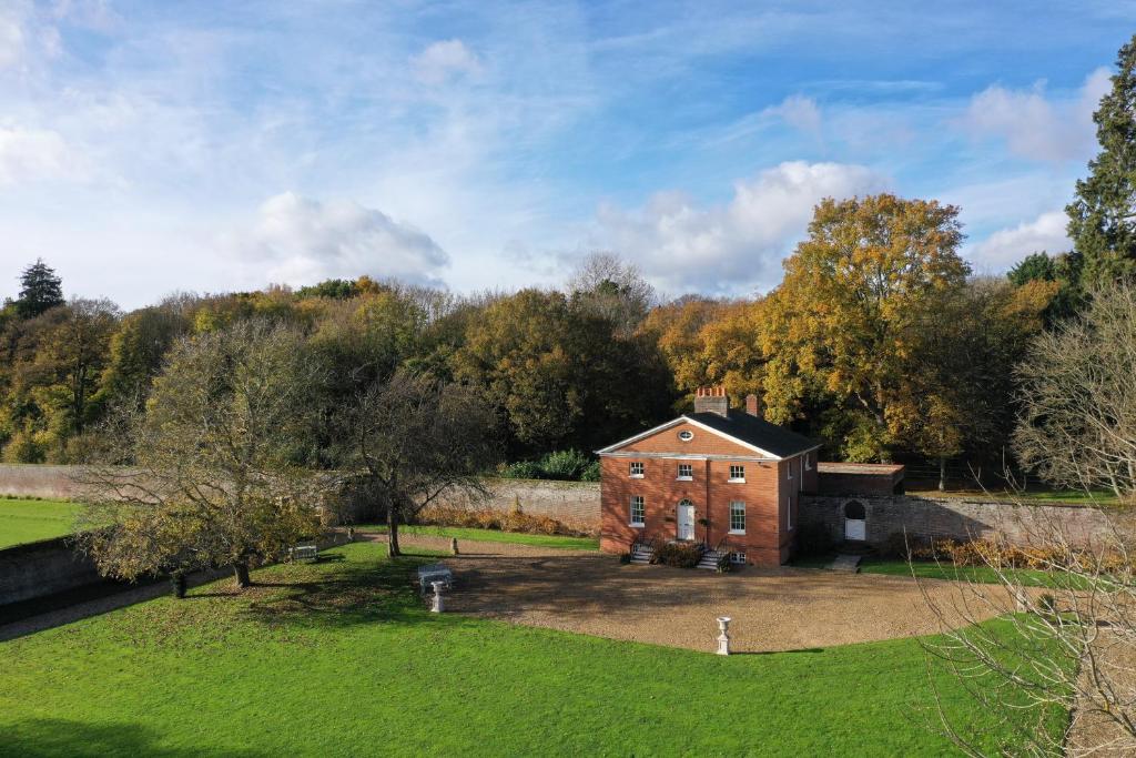 an old brick house in the middle of a field at The Walled Garden at Woodhall Estate in Hertford