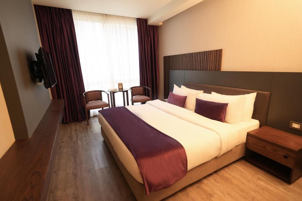 Cette chambre comprend un grand lit et une télévision. dans l'établissement Casa D'or Hotel, à Beyrouth