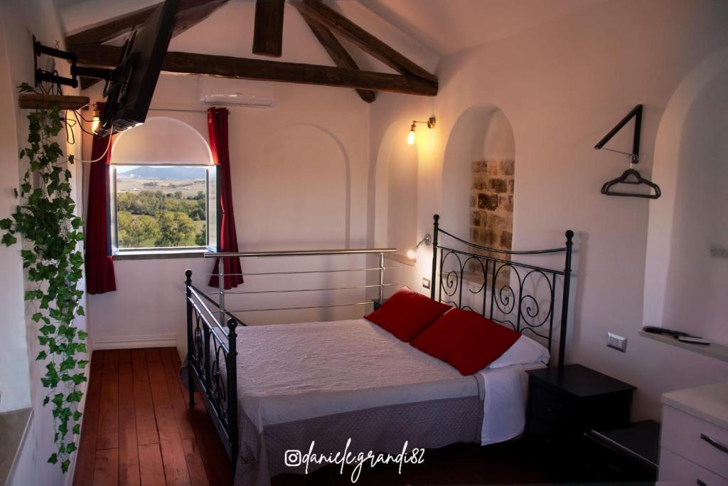 a bedroom with a bed with red pillows and a window at Camera Torre Panoramic in Montalto di Castro