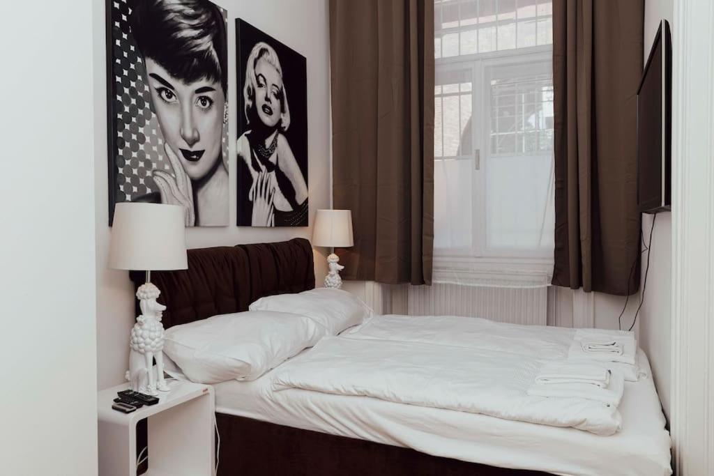 ウィーンにあるModern stylish comfortable 2 bedroom apartmentの壁にポスターが掛けられた部屋のベッド2台