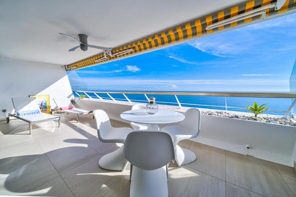 ヴィルヌーヴ・ルベにあるSUNNYの海の景色を望む客室で、テーブルと椅子が備わります。