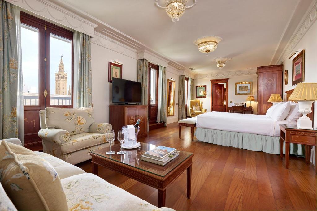 duży pokój hotelowy z łóżkiem i telewizorem w obiekcie Hotel Inglaterra w Sewilli