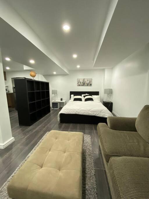 - une grande chambre avec un lit et un canapé dans l'établissement Adorable Quiet Open Concept Private Studio Suite, à Ajax