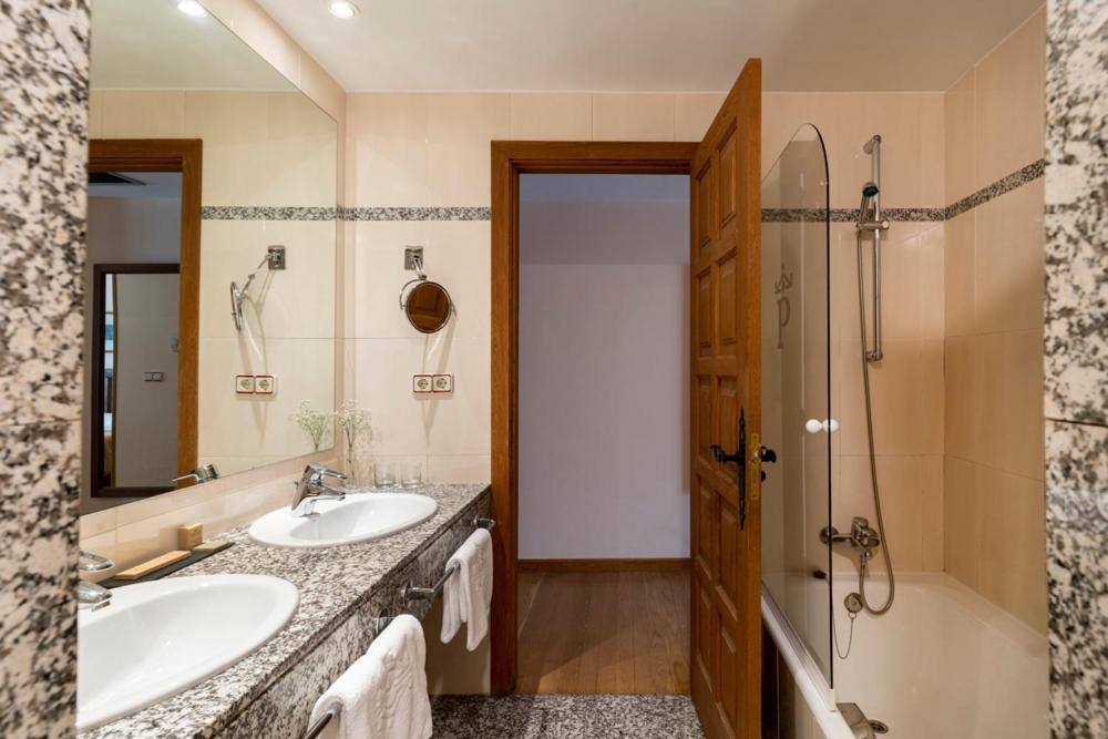 a bathroom with two sinks and a shower at Parador de Vilalba in Villalba
