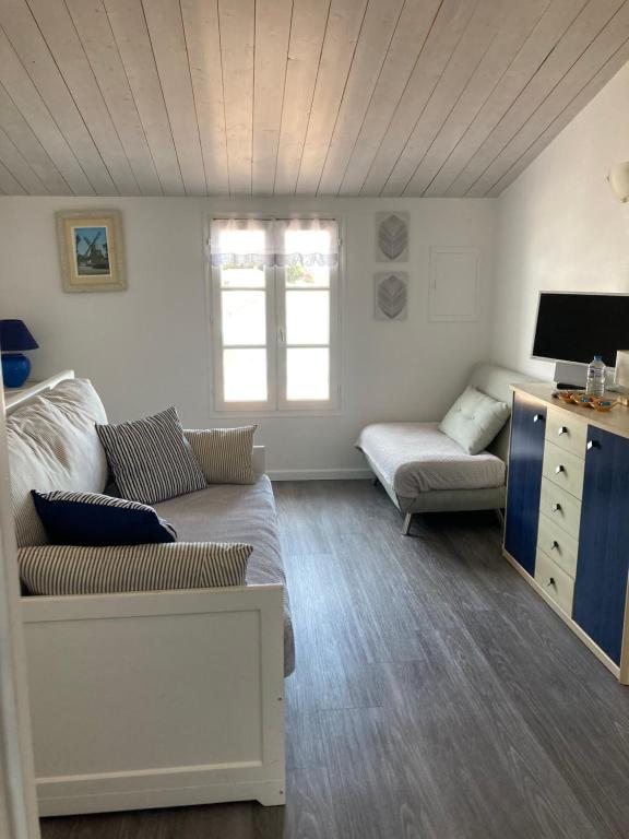 sala de estar con sofá y mesa en Appartement à l’étage indépendant, en Ars-en-Ré