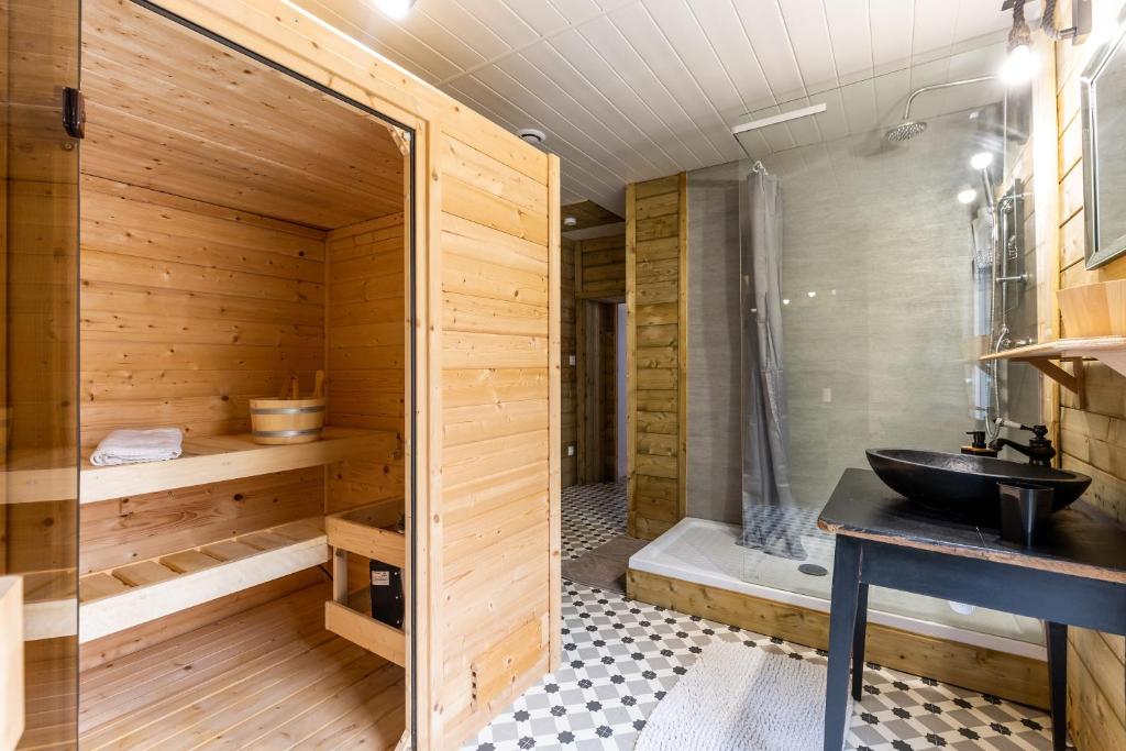 La salle de bains en bois est pourvue d'un lavabo et d'une douche. dans l'établissement Gite bien etre sauna et spa, à Vertheuil-en-Médoc