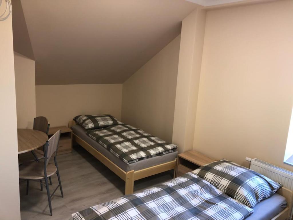 a room with two beds and a table in a room at GOLENICKA PRZYSTAŃ in Golenice