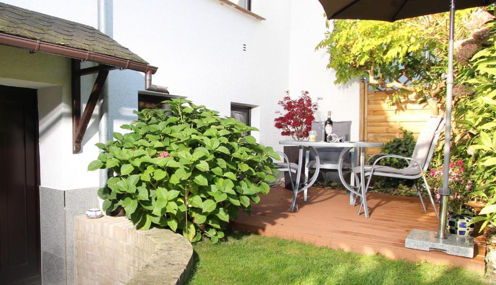 a patio with a table and chairs in a yard at Juju in Fulgen