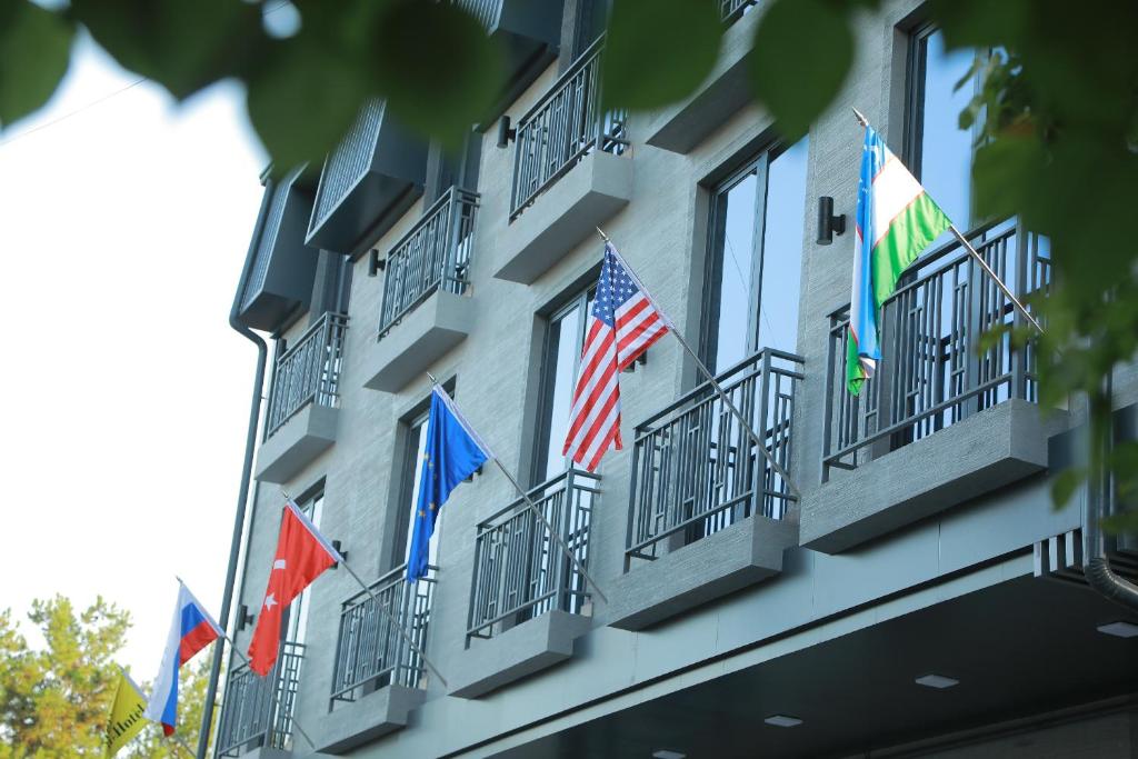 a building with american and european flags on the balconies at Human Hotel in Tashkent