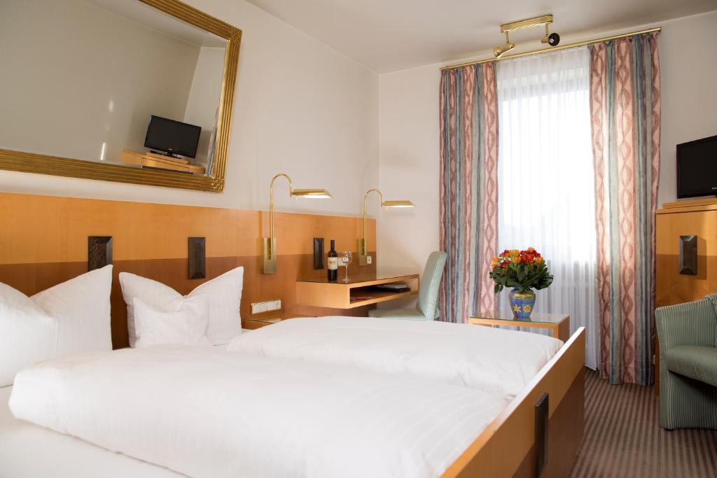 a hotel room with a large bed and a mirror at Hotel Dietmayr in Neumarkt in der Oberpfalz