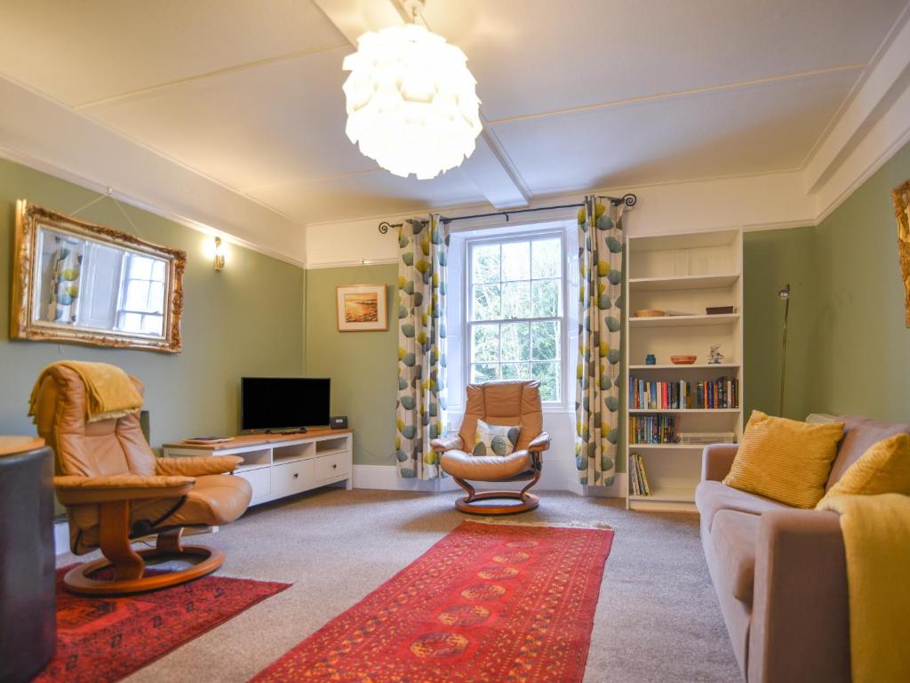 a living room with a couch and chairs and a television at Flat 3, St Agnes House in Lyme Regis