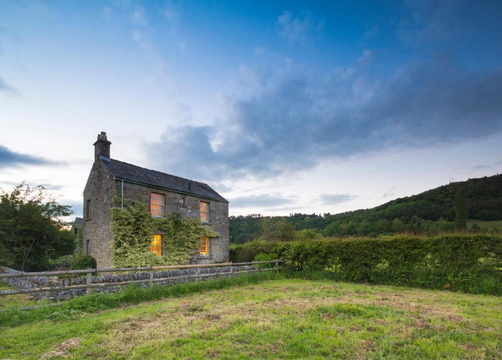 an old stone house in a field at The Old Cart Shed in the Peak District in Bakewell
