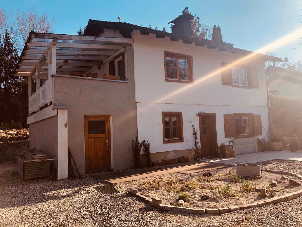 a white house with the sun shining on it at Fischerhaus in Burgthann