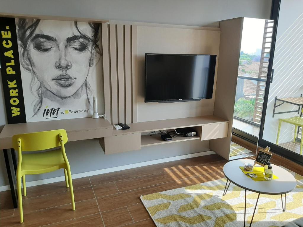 salon z telewizorem i żółtym krzesłem w obiekcie You Suite by INN w mieście Santa Cruz de la Sierra