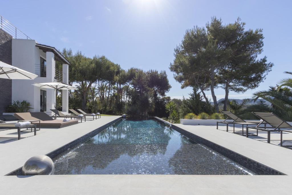 a swimming pool in the backyard of a house at Magical Ibizan Villa Walking Distance To The Beach Es Vedre Style 6 Bedrooms Fabulous Sea Views San Jose in Sant Josep de sa Talaia