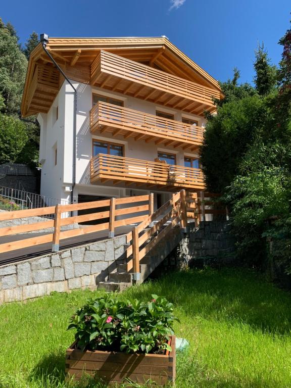 ein Haus mit einer Terrasse und einer Pflanze davor in der Unterkunft Casa al Sole Apt 1 in Pinzolo