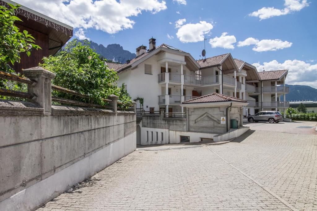 duży biały dom ze ścianą i ulicą w obiekcie Casa Serena w mieście San Candido