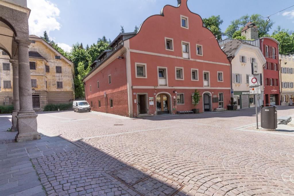 a cobblestone street in a town with a red building at Central Attic - Castle view in Brunico