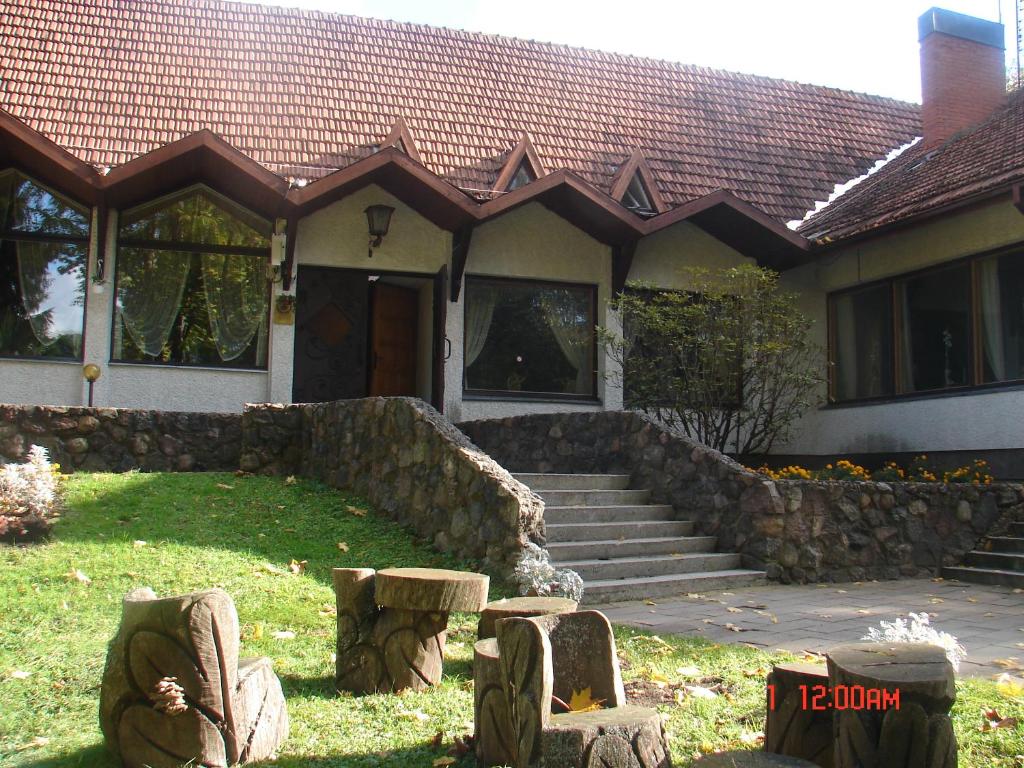 una casa con una pared de piedra delante de ella en Senieji Bačkonys, en Bačkonys