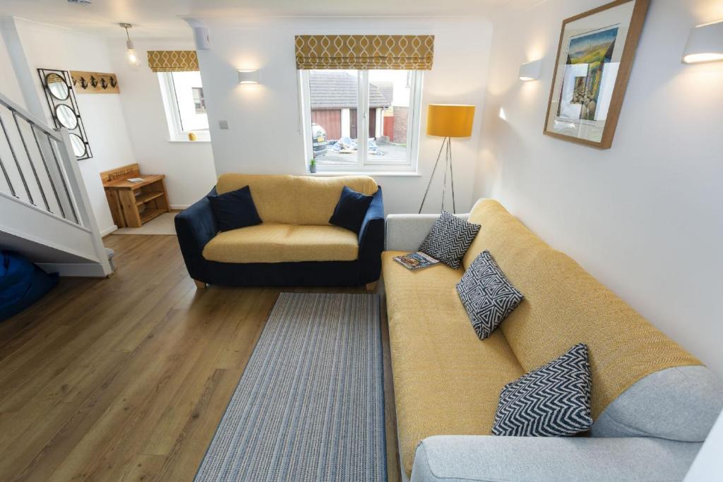 CROYDE PEBBLES 4 Bedrooms في كرويد: غرفة معيشة مع أريكة وكرسي