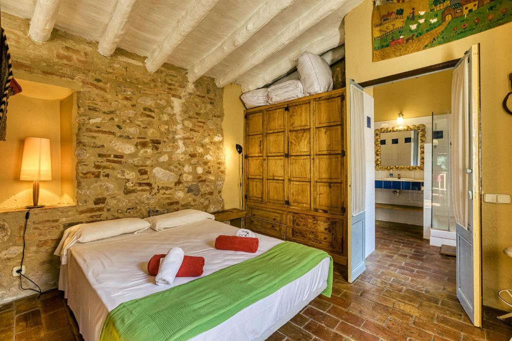 a bedroom with a bed and a stone wall at Can Lluna Rural House in Avinyonet de Puigventós