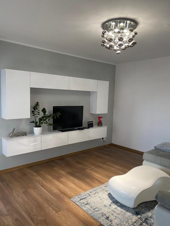 a white living room with a tv and a couch at Apartament Rezydencja Metropolis ul.Dąbrowa 15 in Bydgoszcz