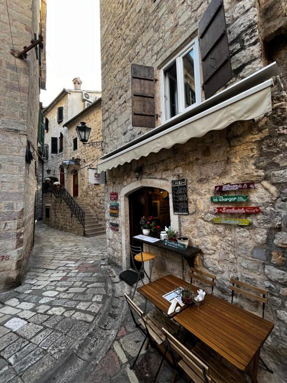 un banc en bois assis à l'extérieur d'un bâtiment dans l'établissement Guesthouse Athos, à Kotor