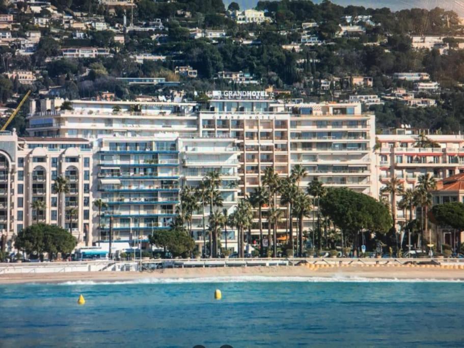 - une vue sur la plage avec un grand bâtiment dans l'établissement Eider, à Cannes