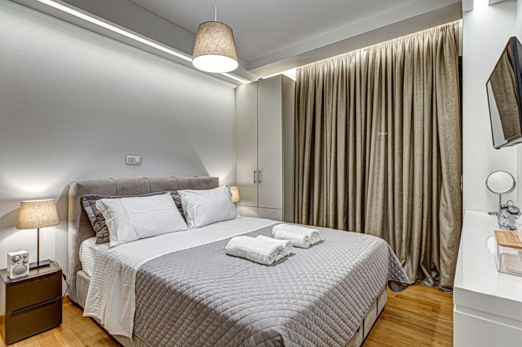 sypialnia z łóżkiem i oknem w obiekcie Deluxe & Modern Apartment In Athens w Atenach