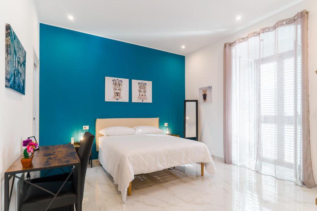 a blue bedroom with a bed and a blue wall at GUENDALINA SWEET HOME - LA CASETTA Di GUENDALINA in Trani